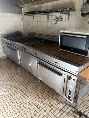un micro-ondes posé sur une cuisinière dans une cuisine