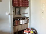 a book shelf with books on top of it in the corner of a room