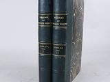 two black books sitting on top of each other on a white surface