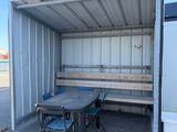 a table and chairs in the back of a shipping container