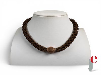 collier composé de perles marron avec un fermoir en bronze, porté par un mannequin blanc