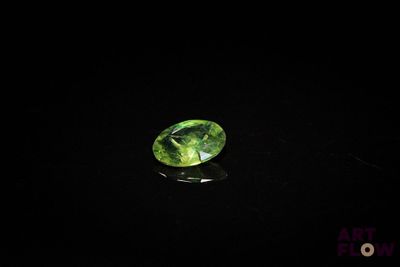 a green tourmaline gems on a black surface