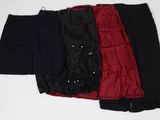trois paires de pantalons noirs, rouges et noirs posés sur une surface blanche