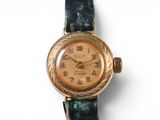 a gold wrist watch with roman numerals on it