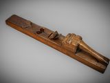 an old wooden plane with a wooden handle on a gray background