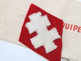 a red and white bag with a white cross on it