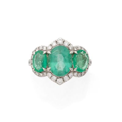 une bague à trois pierres, composée d'une émeraude et de diamants