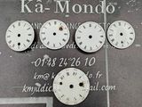 cinq horloges accrochées au mur d'un immeuble sur lequel est accrochée une enseigne