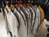 a lot of jackets hanging on a rack in a store