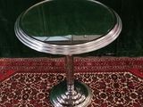 a small round table with a glass top on a rug