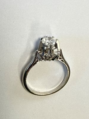 une image d'une bague en diamant sur une surface blanche