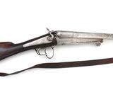 un vieux fusil avec une poignée en bois sur fond blanc