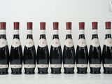 six bouteilles de vin sont alignées sur une table