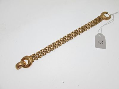 Gros plan sur un bracelet en chaîne en or portant une étiquette