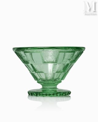 a green glass bowl sitting on top of a white table