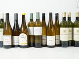 plusieurs bouteilles de vin sont alignées sur une surface blanche