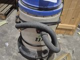 a blue and silver vacuum sitting on the floor