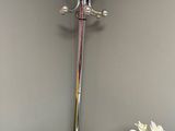 a vase with flowers on a table next to a coat rack