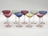 six different colored wine glasses are lined up in a row