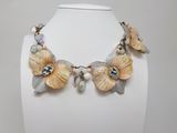 a white mannequin with flowers and pearls on it