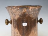 an old copper vase with handles on a white surface