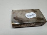 a silver box with a label on it on a table
