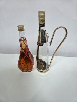 BOUTEILLES, bouteilles à alcools en verre, l'une montée sur …