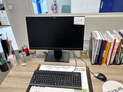 a computer monitor and keyboard on a desk in an office