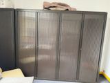 une armoire métallique dans un coin de la pièce, à côté d'une chaise