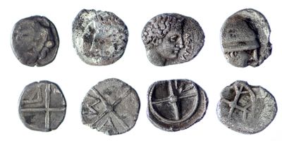 a close up of a group of ancient coins on a white surface