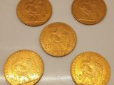 quatre pièces d'or sont posées sur une surface blanche