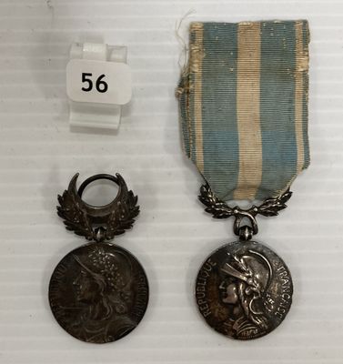 deux médailles et une médaille sur une surface blanche