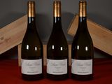 three bottles of wine sitting next to a wooden box on a table