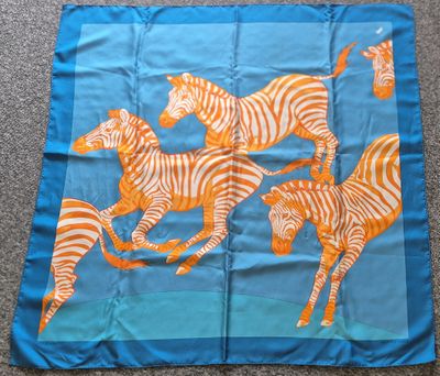 foulard en soie bleu et orange orné de zèbres et de girafes