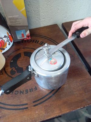 a person holding a knife over a pot on a table