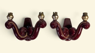une paire d'appliques murales rouges, chacune dotée de ferrures en laiton