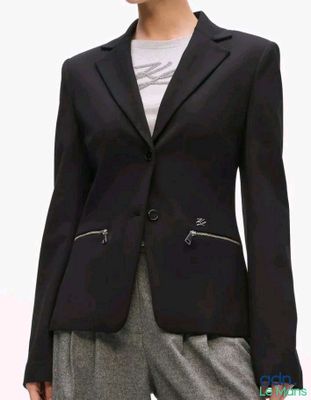 La femme porte une veste noire munie de fermetures éclair.
