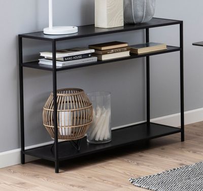 une étagère noire sur laquelle sont posés une lampe et un vase