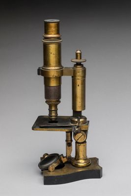 a close up of a microscope on a table with a gray background