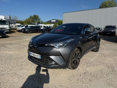 a grey toyota c - hr is parked in a parking lot