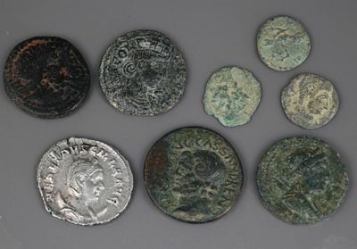 six pièces de monnaie romaines anciennes, dont l'une représente une tête de lion et l'autre une tête de lion