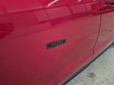 a close up of a red car with a sticker on it