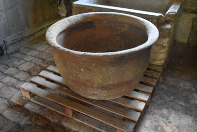 a large stone pot sitting on a pallet in a room
