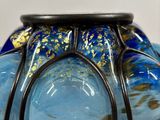 a blue glass bowl with a gold leaf decoration on it