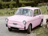 a pink car that is parked on the side of the road