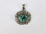 un pendentif en argent orné d'une pierre turquoise au centre
