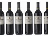 six bottles of red wine are lined up in a row