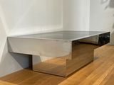 a silver bench sitting on top of a wooden floor