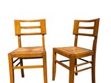 pair of wooden chairs against a white background