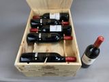 bottles of red wine in a wooden box on a table
